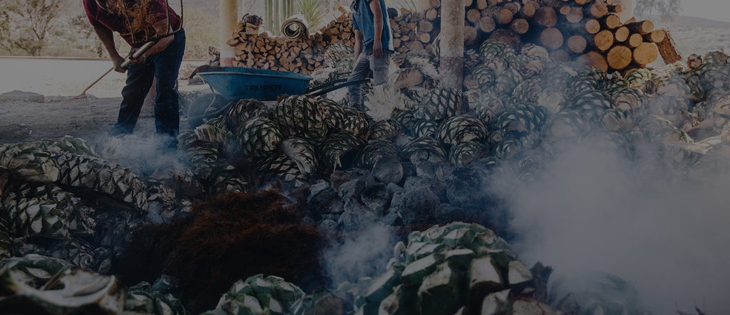Workers smoking Mezcal plants for the production of Mezcal used as the image header for the Mezcal Collection at T. Edward Wine & Spirits